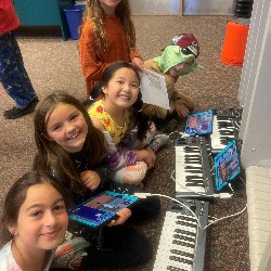 Third grade girls use keyboards and ipads to connect music and technology.